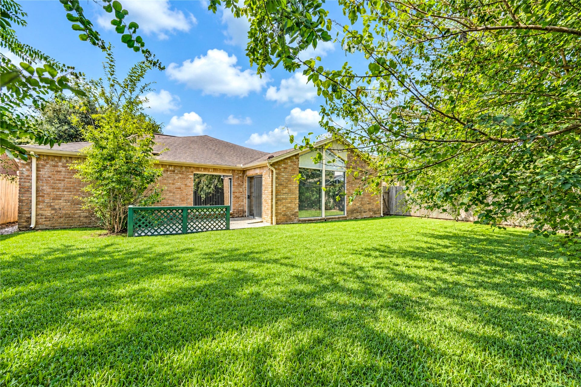 361 Champions Colony III, Houston, TX 77069 Spacious backyard with lush green lawn and mature trees, offering a private and serene outdoor space ideal for relaxation and entertaining.