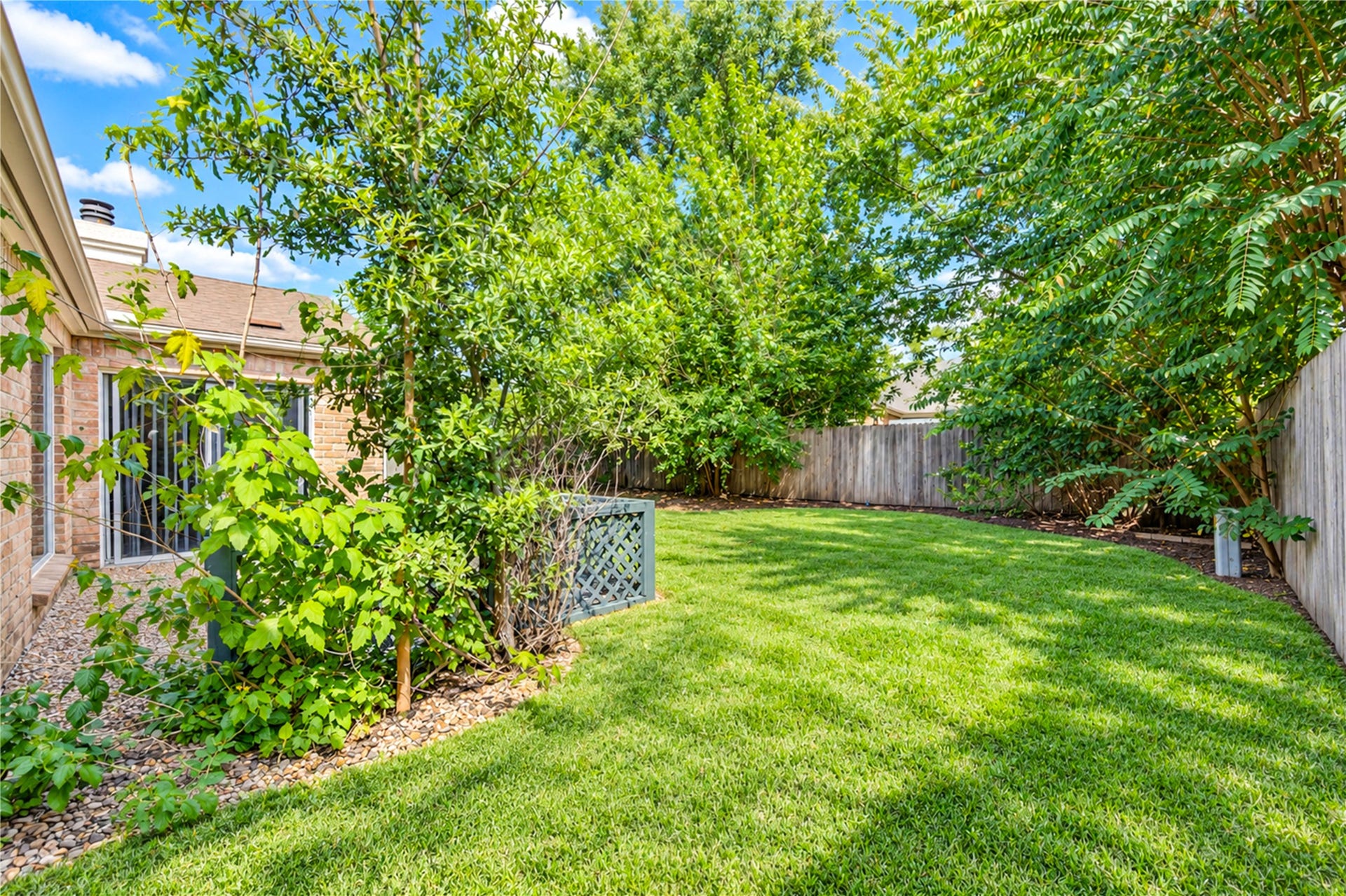 361 Champions Colony III, Houston, TX 77069 Lush green backyard with mature trees offers privacy and a serene outdoor space, perfect for relaxation and entertaining.
