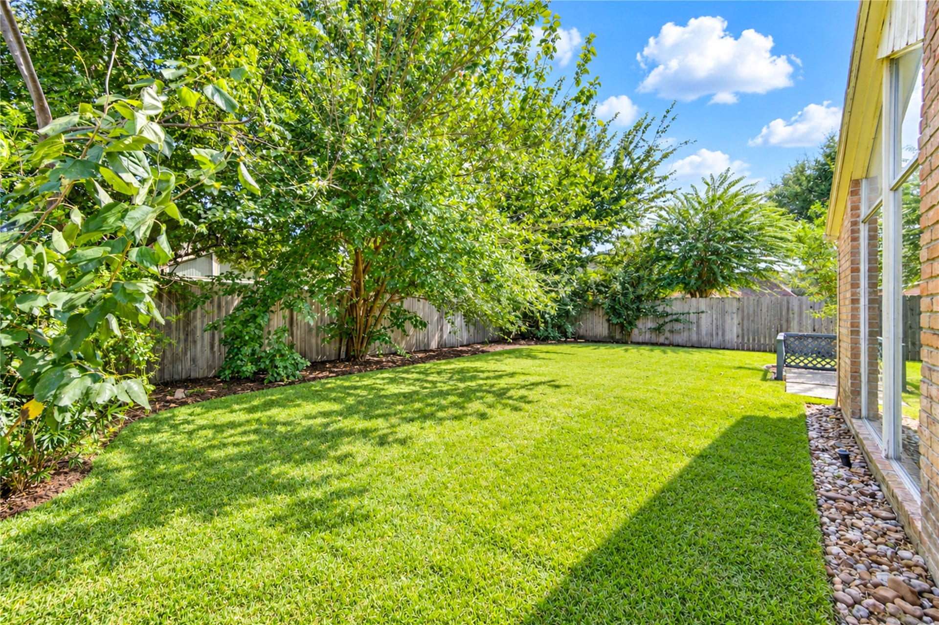 361 Champions Colony III, Houston, TX 77069 Expansive backyard with lush green lawn, mature trees for shade, and a privacy fence, perfect for outdoor activities and relaxation.