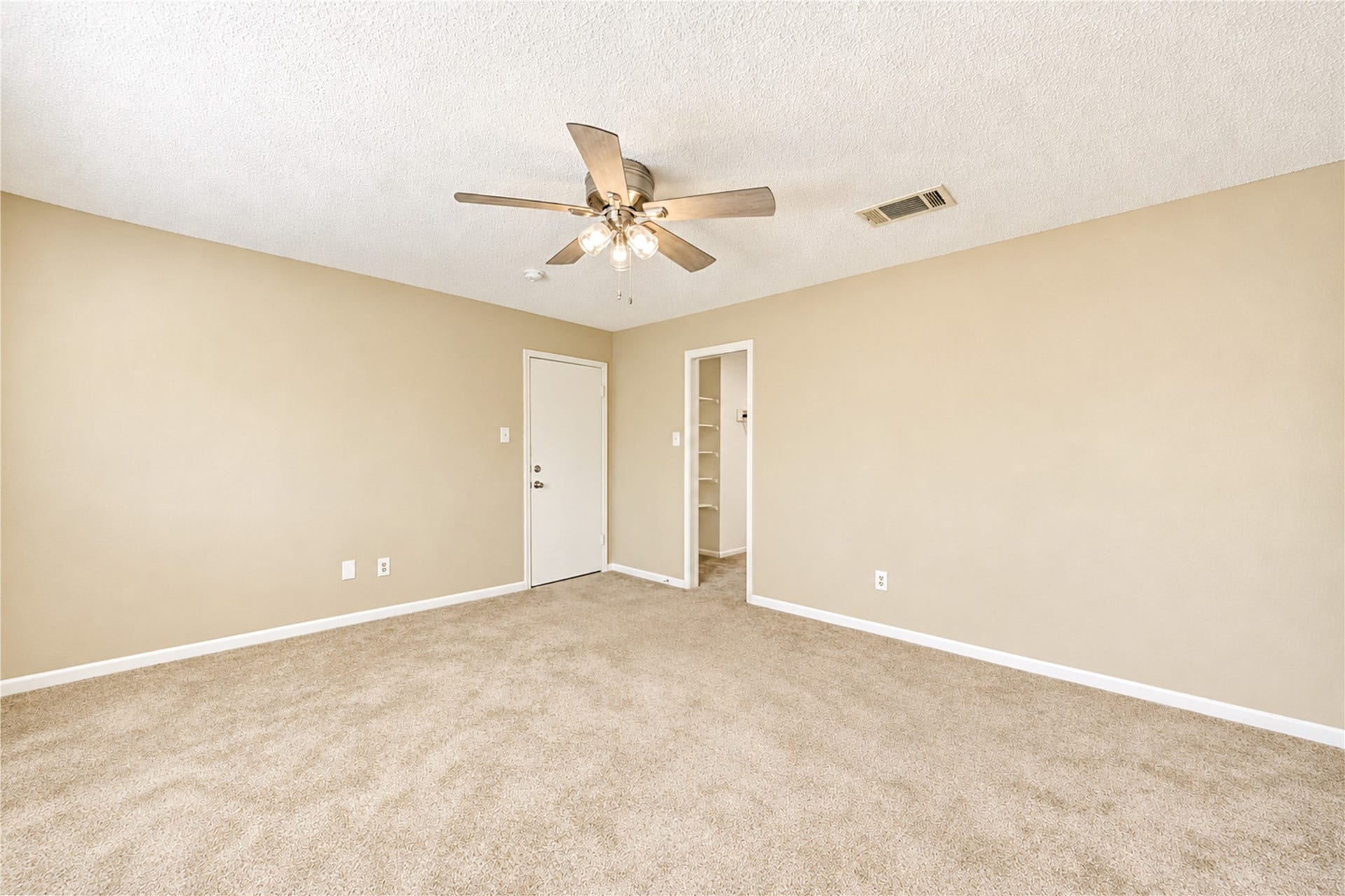361 Champions Colony III, Houston, TX 77069 Spacious bedroom featuring plush carpet, neutral walls, a ceiling fan for comfort, and access to a walk-in closet.