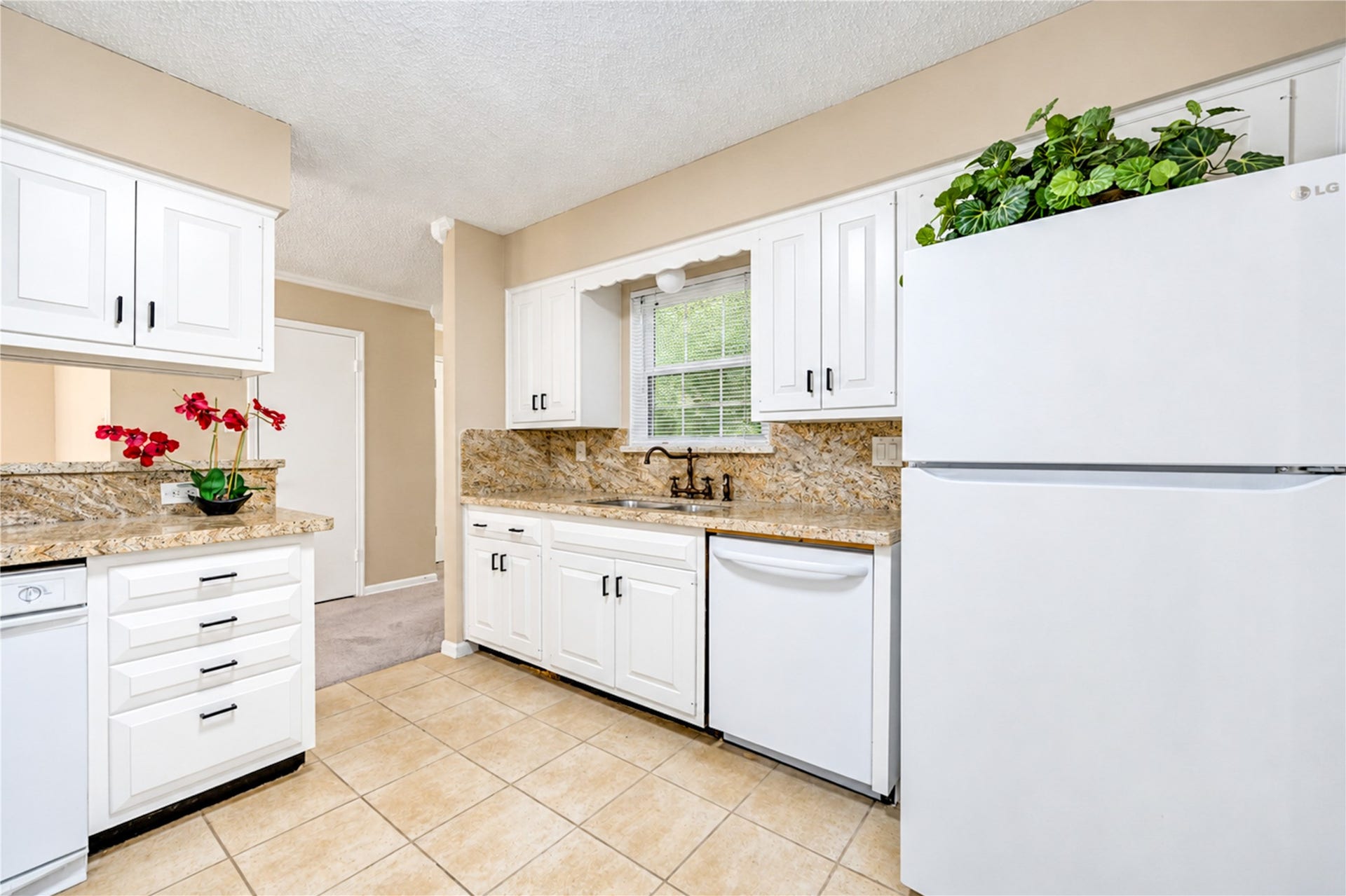 361 Champions Colony III, Houston, TX 77069 Bright kitchen with elegant granite countertops, white cabinetry, and modern appliances, offering a clean and inviting space for cooking and entertaining.