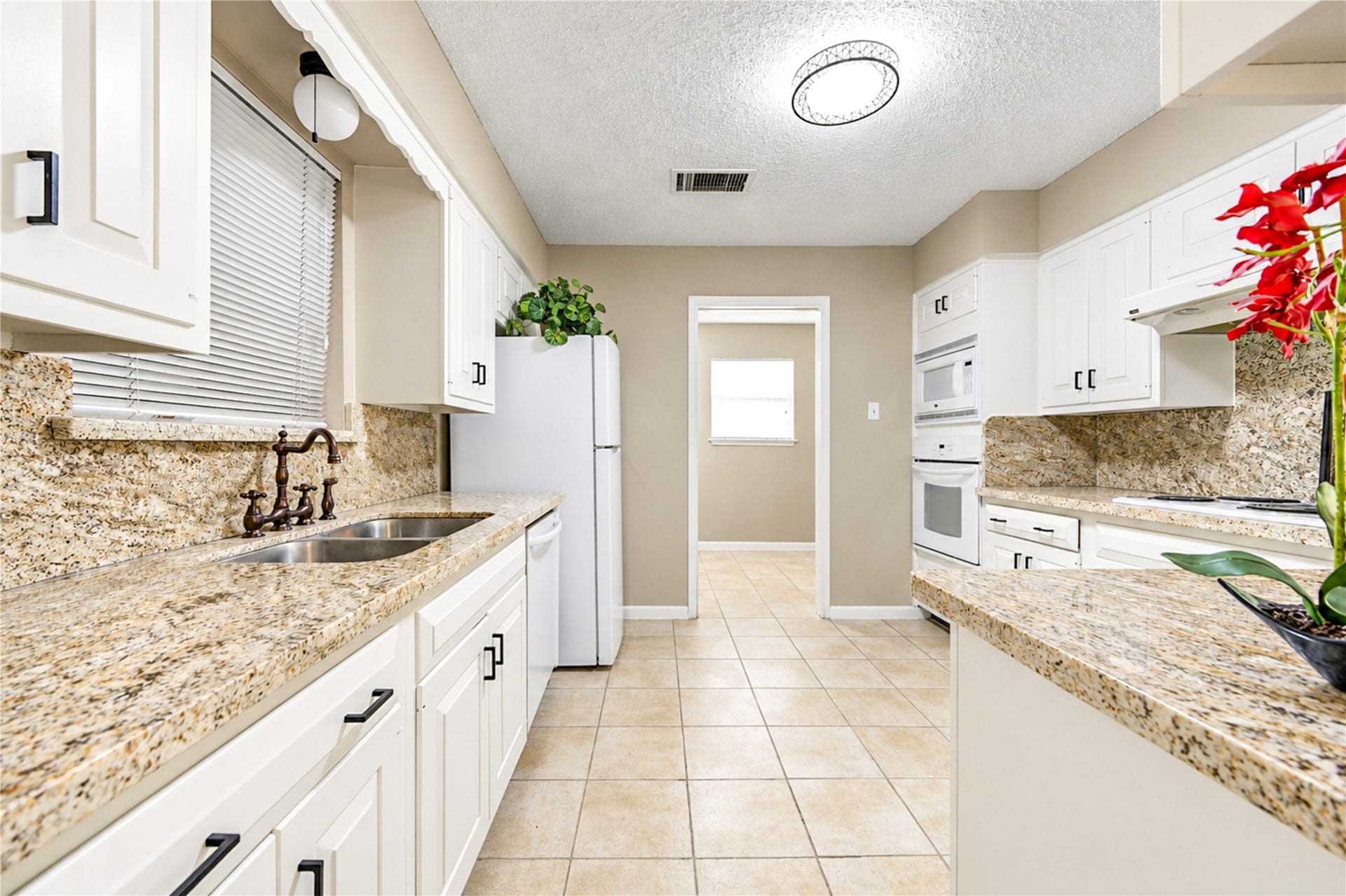361 Champions Colony III, Houston, TX 77069 Elegant kitchen with granite countertops, white cabinetry, and modern appliances, offering ample space and a bright atmosphere.