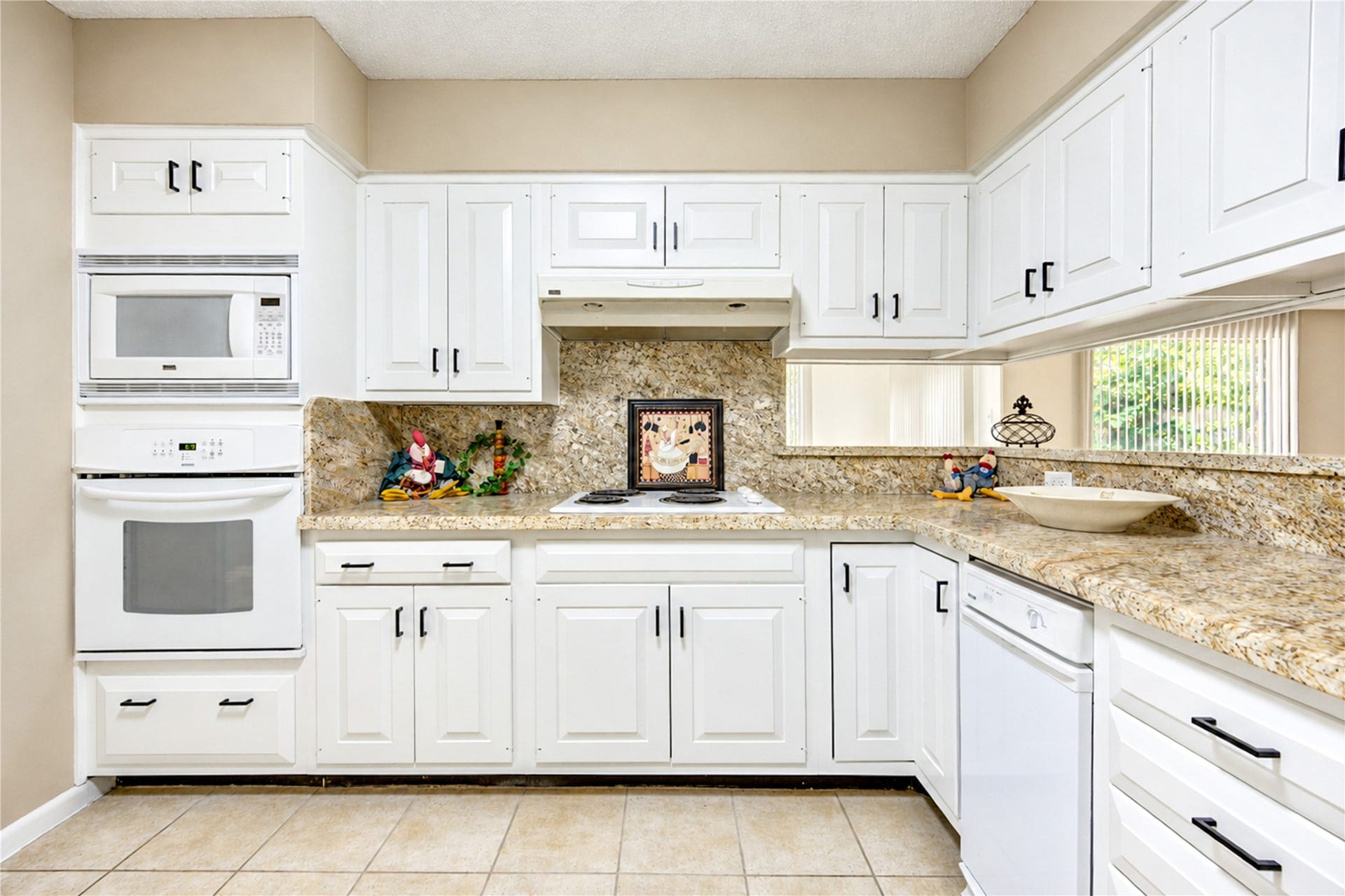 361 Champions Colony III, Houston, TX 77069 Bright, modern kitchen featuring elegant white cabinetry, granite countertops, and built-in appliances for a sleek, functional space.