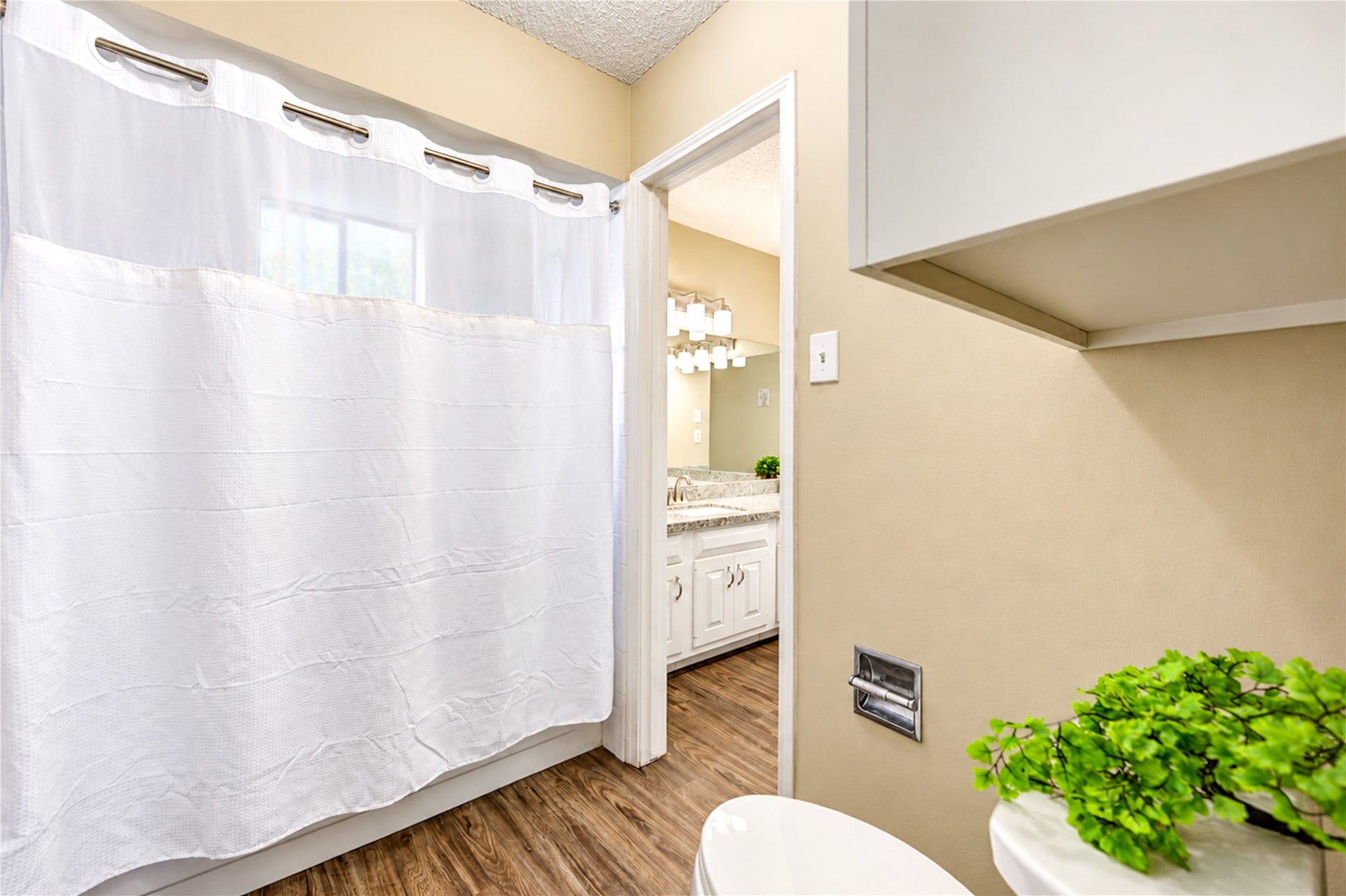 361 Champions Colony III, Houston, TX 77069 Bright bathroom with a sleek white vanity, modern fixtures, and a fresh ambiance enhanced by natural light and a touch of greenery.