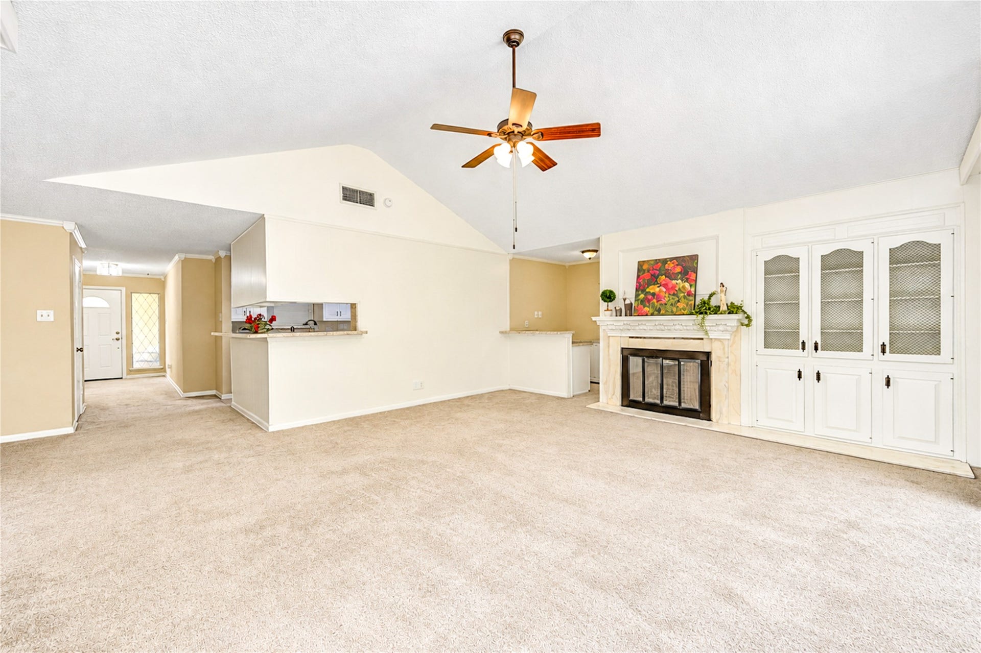 361 Champions Colony III, Houston, TX 77069 Spacious living area with vaulted ceilings, a cozy fireplace, and built-in cabinetry, complemented by an open layout leading to the kitchen.