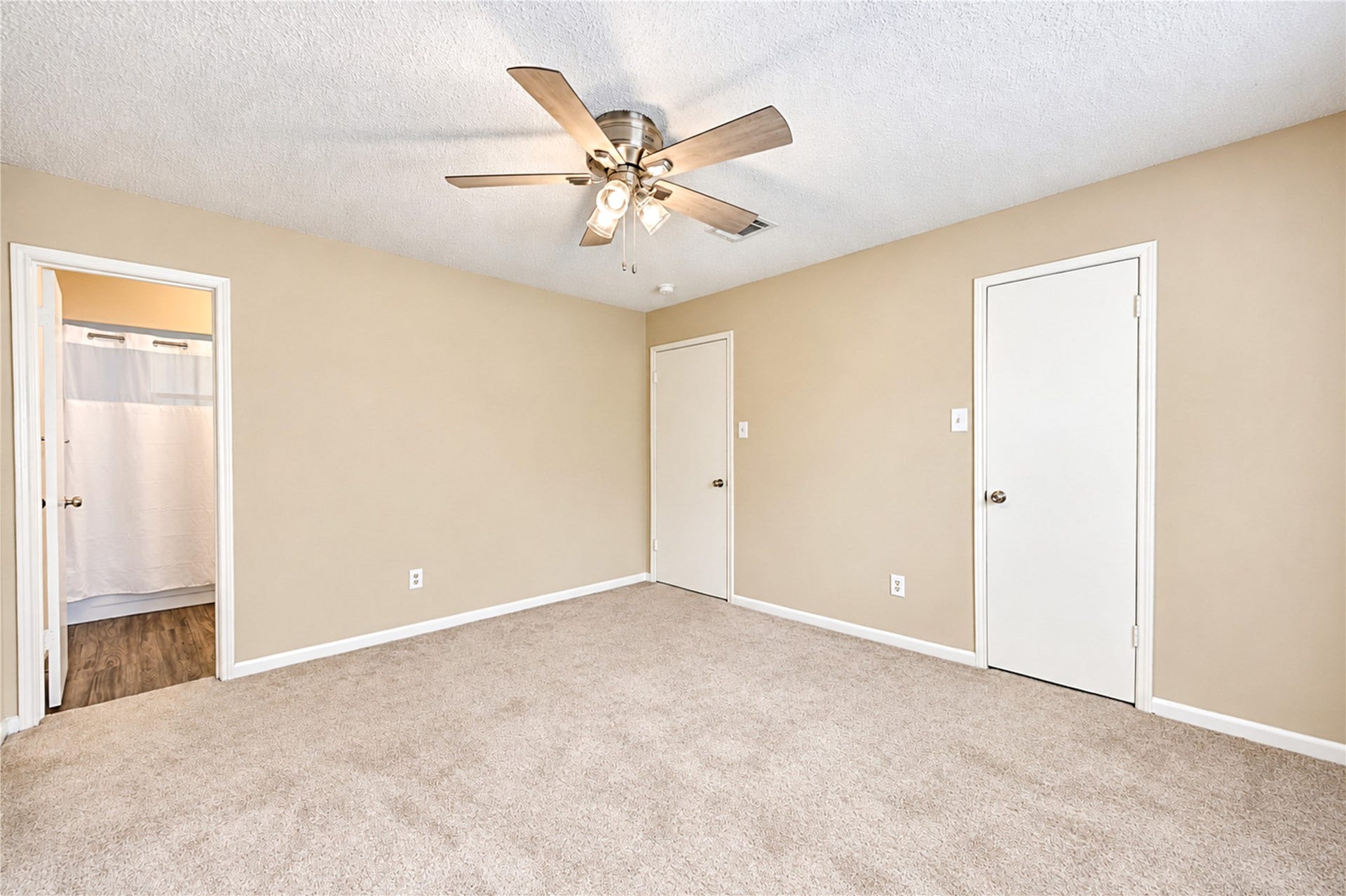 361 Champions Colony III, Houston, TX 77069 Spacious bedroom featuring soft carpet, a ceiling fan, and access to an en-suite bathroom with modern flooring.