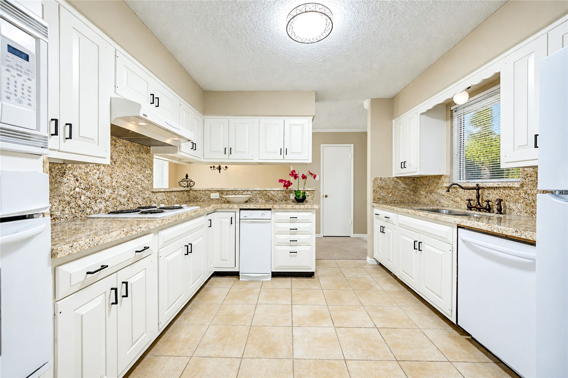 361 Champions Colony III, Houston, TX 77069 Charming kitchen with elegant white cabinetry, granite countertops, and modern appliances, complemented by ample natural light and a cozy atmosphere.