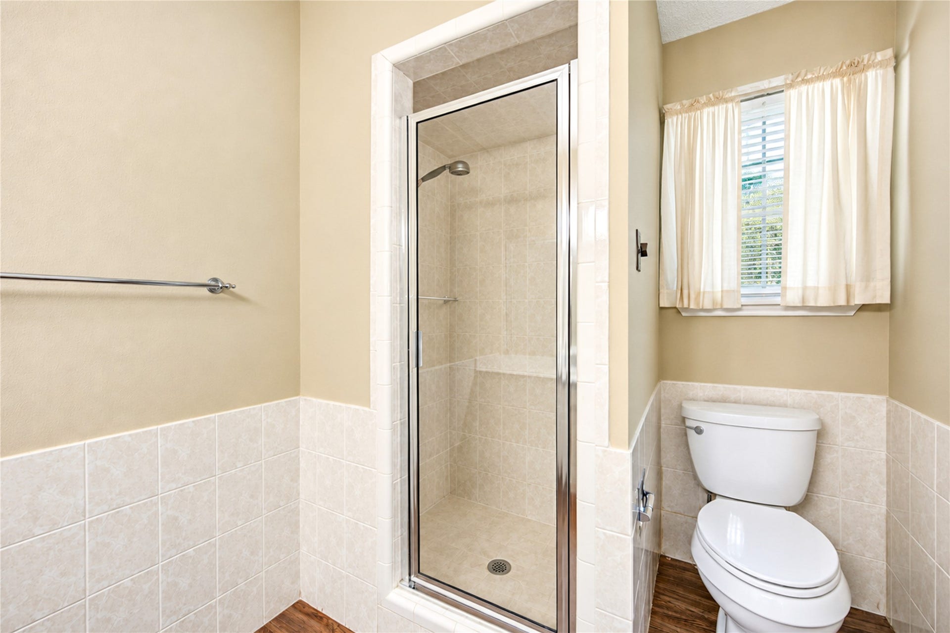 361 Champions Colony III, Houston, TX 77069 Bright bathroom featuring a tiled walk-in shower, modern fixtures, and natural light from a window with soft curtains.
