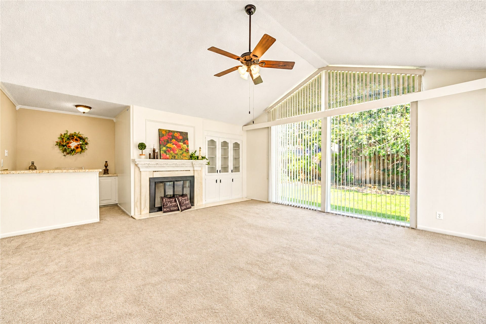 361 Champions Colony III, Houston, TX 77069 Spacious living room with vaulted ceilings, a cozy fireplace, and expansive windows offering abundant natural light and views of the lush backyard.