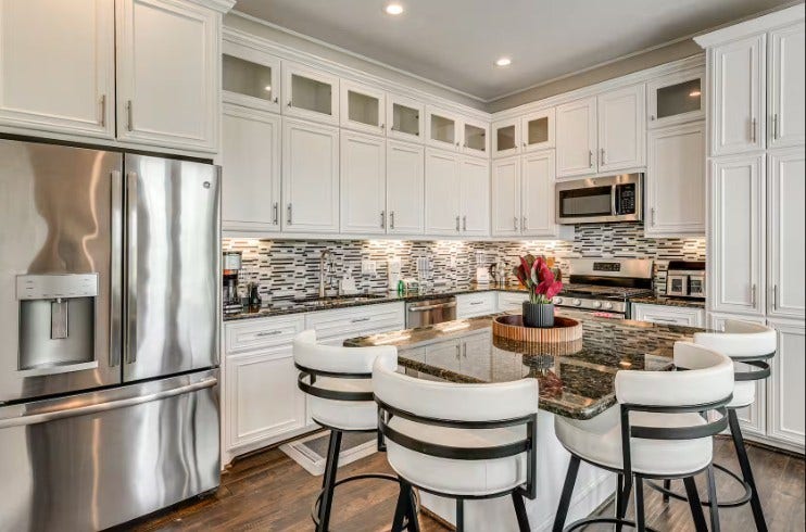 1013 10th Street, Galveston, TX 77550 Elegant and fully furnished kitchen with modern stainless steel appliances, sleek cabinetry, and a stylish island for gatherings.