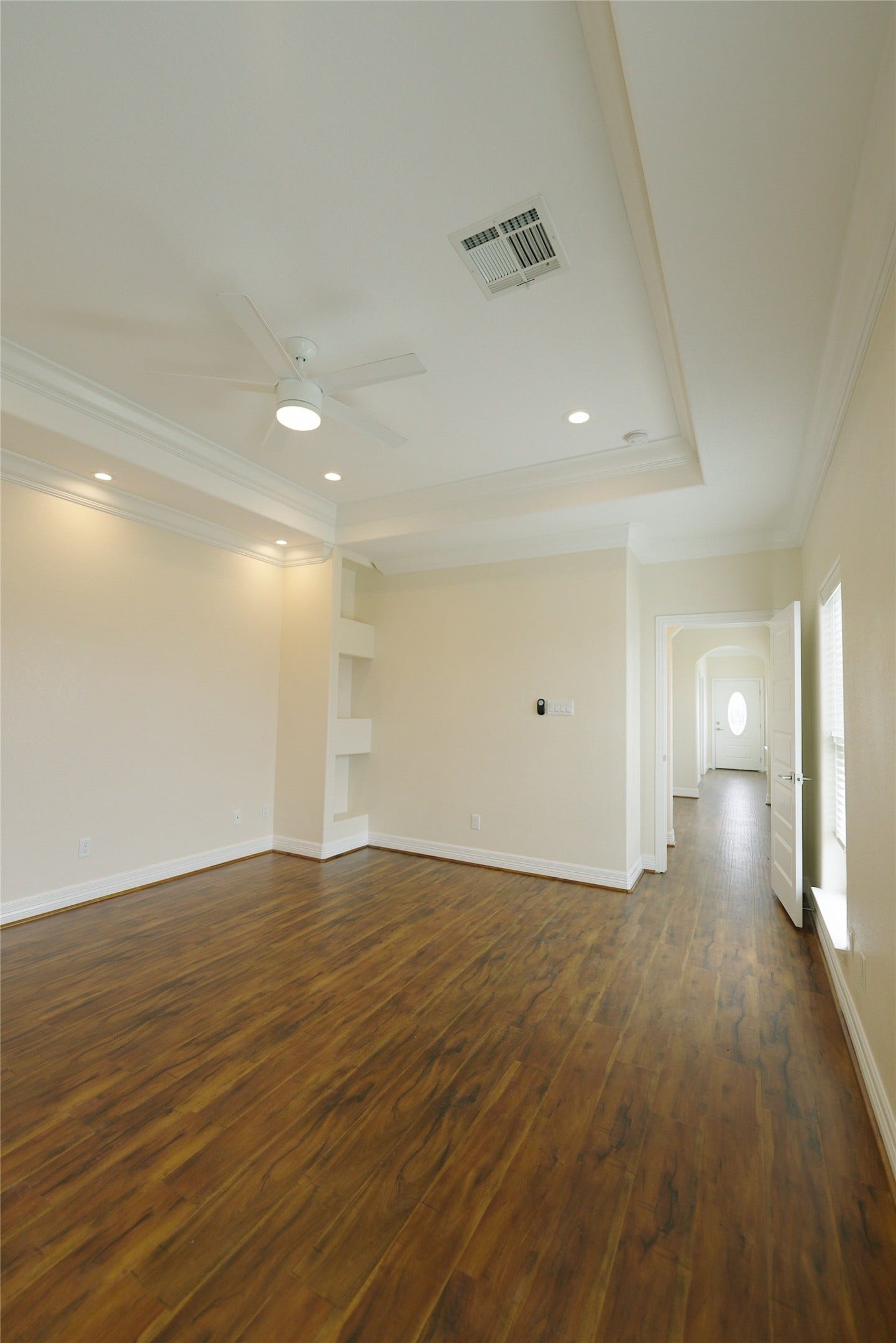 1013 10th Street, Galveston, TX 77550 Luxurious top-level primary bedroom featuring elegant recessed lighting and stunning hardwood floors.