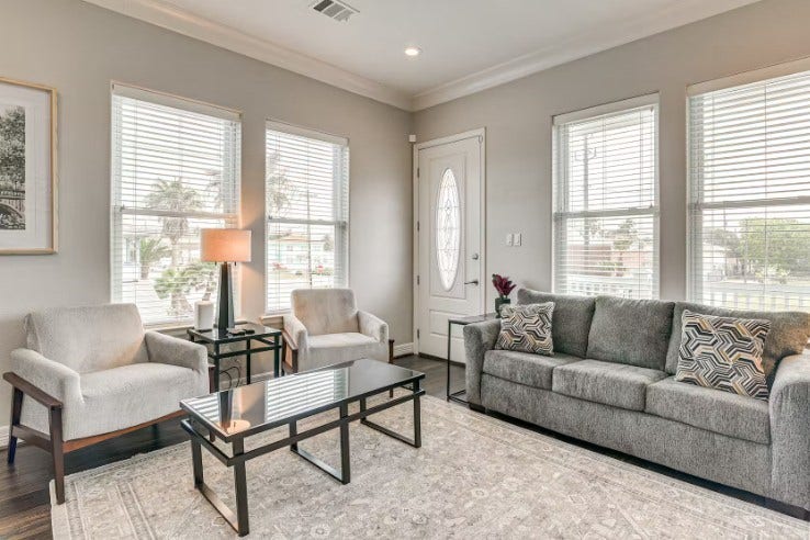 1013 10th Street, Galveston, TX 77550 1013 10th A Charming living room with ample natural light, stylish furnishings, and cozy seating, perfect for relaxation.