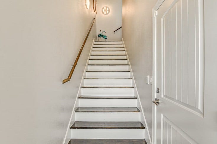 1013 10th Street, Galveston, TX 77550 Elegant entry staircase in a fully furnished home at 1013 10th A, offering a warm welcome.