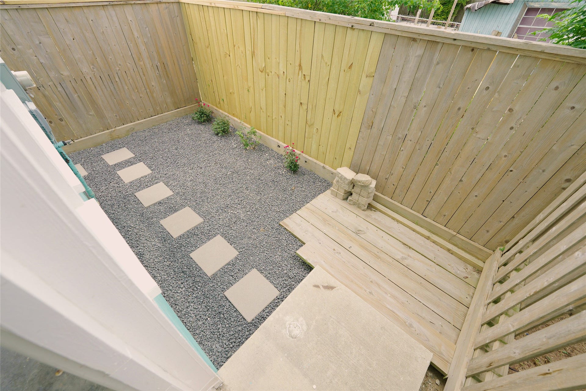1013 10th Street, Galveston, TX 77550 Charming back porch with a private, fenced-in area featuring a low-maintenance gravel path and cozy wooden deck, perfect for relaxation.