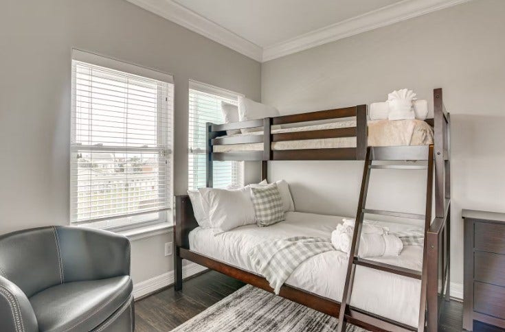1013 10th Street, Galveston, TX 77550 Elegant top-level guest bedroom, fully furnished with cozy twin bunk beds and abundant natural light.