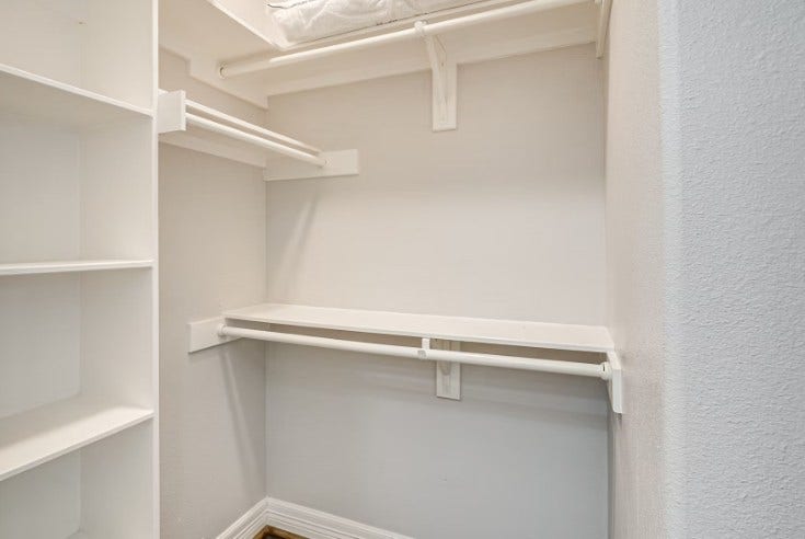 1013 10th Street, Galveston, TX 77550 Spacious walk-in closet with ample shelving and hanging space, perfect for organizing your wardrobe.