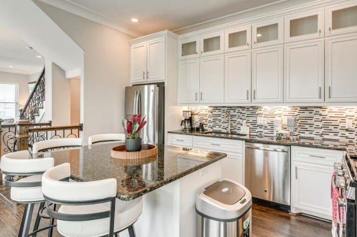 1013 10th Street, Galveston, TX 77550 Elegant and fully furnished kitchen featuring sleek cabinetry, modern appliances, and a spacious island with seating, perfect for cooking and entertaining.