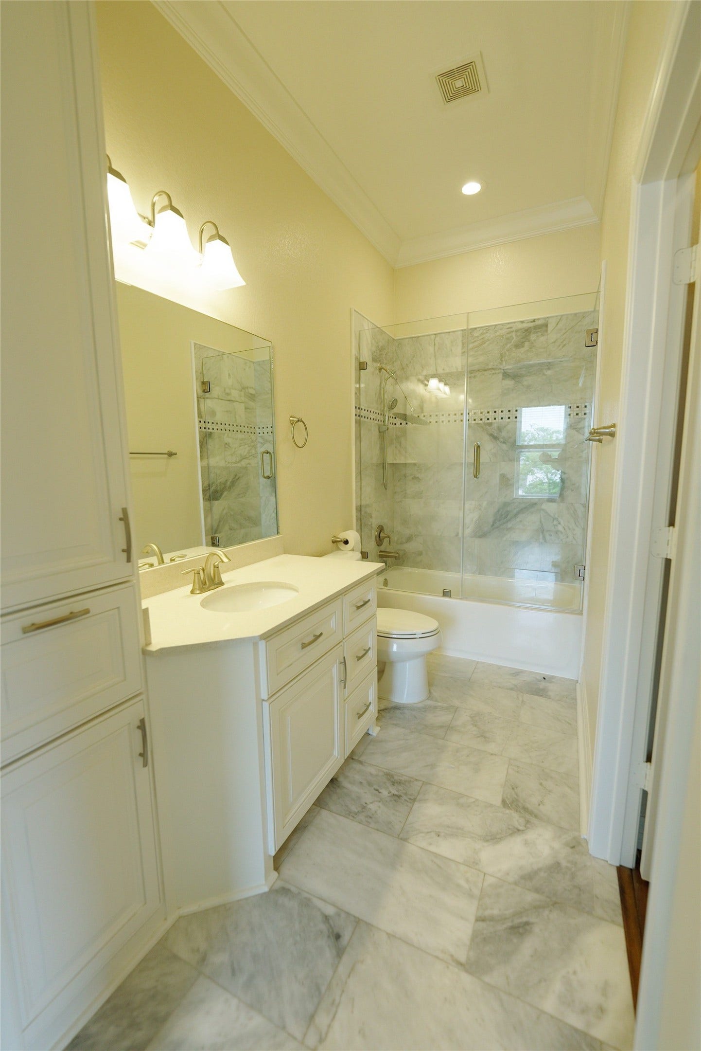 1013 10th Street, Galveston, TX 77550 Luxurious guest bathroom featuring elegant marble finishes and modern recessed lighting. Currently tenant occupied.
