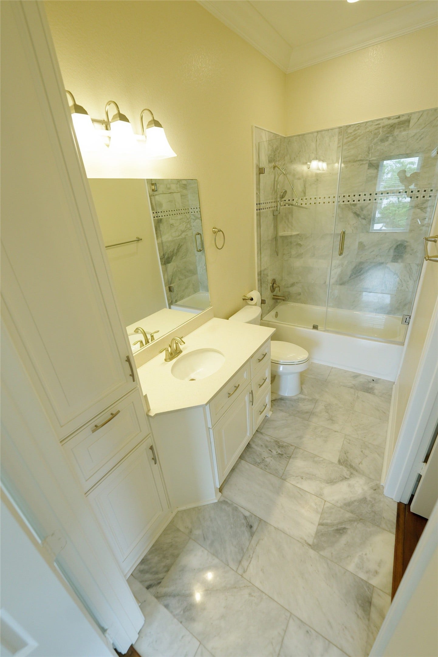 1013 10th Street, Galveston, TX 77550 Elegant guest bathroom with marble flooring and a modern shower, currently tenant occupied.