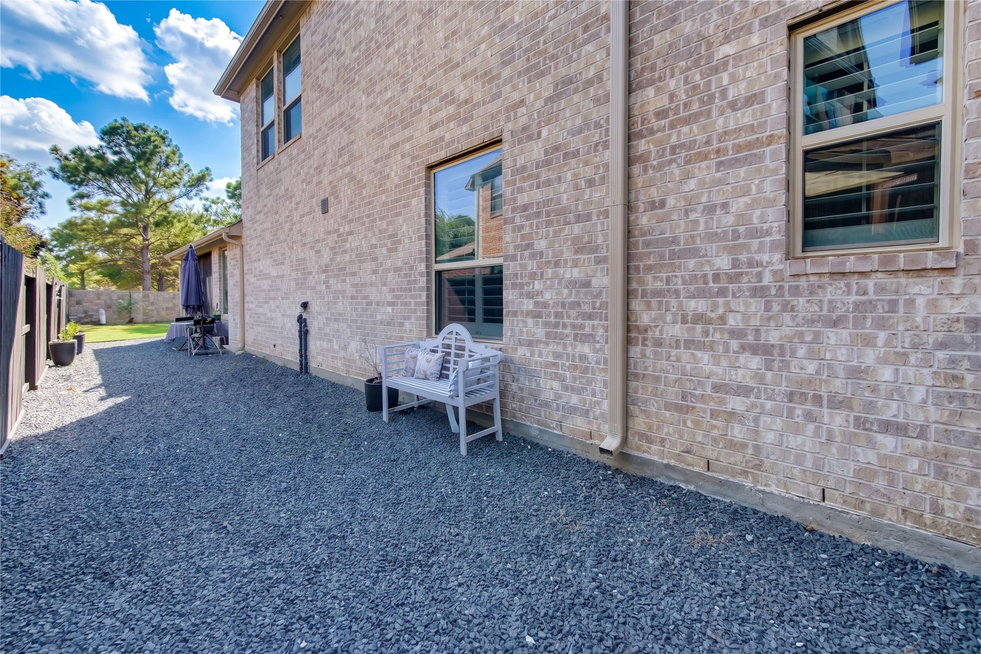 The side of the home features a convenient pebble-rock landscape, offering a clean, low-maintenance alternative to traditional landscaping.