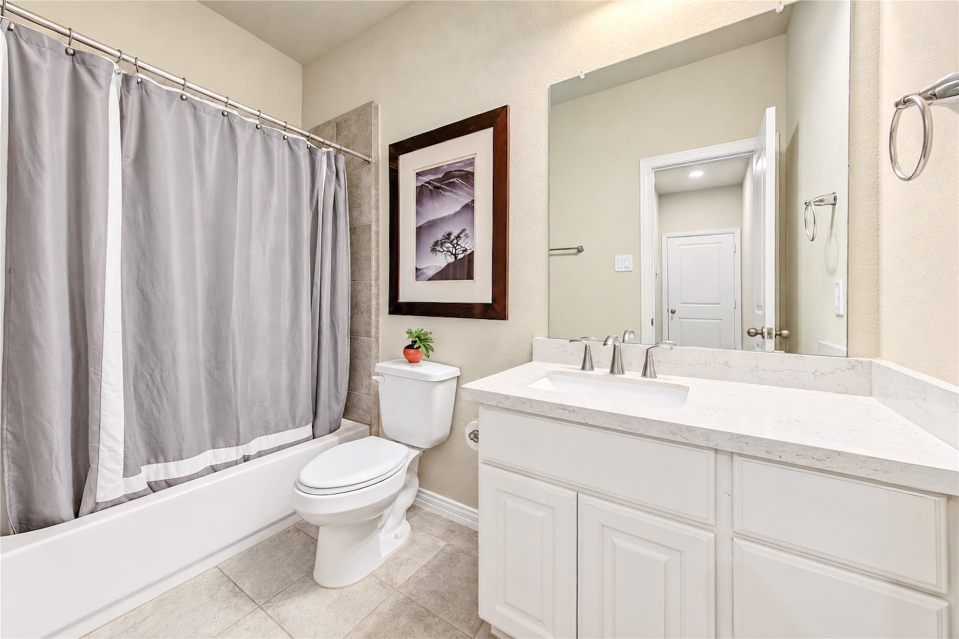 The first-floor bathroom is privately tucked away along a hallway near the downstairs secondary bedroom, offering added convenience and privacy for guests.