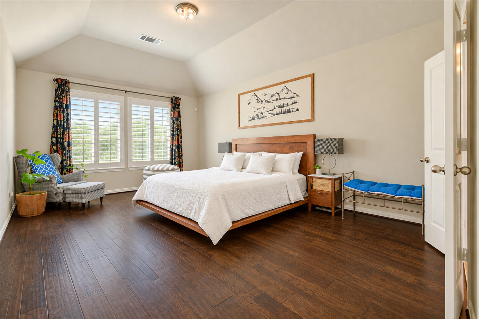 The first-floor primary suite offers peaceful backyard views, soaring vaulted ceilings, and abundant space to accommodate a king-sized bedroom set along with a comfortable sitting area.
