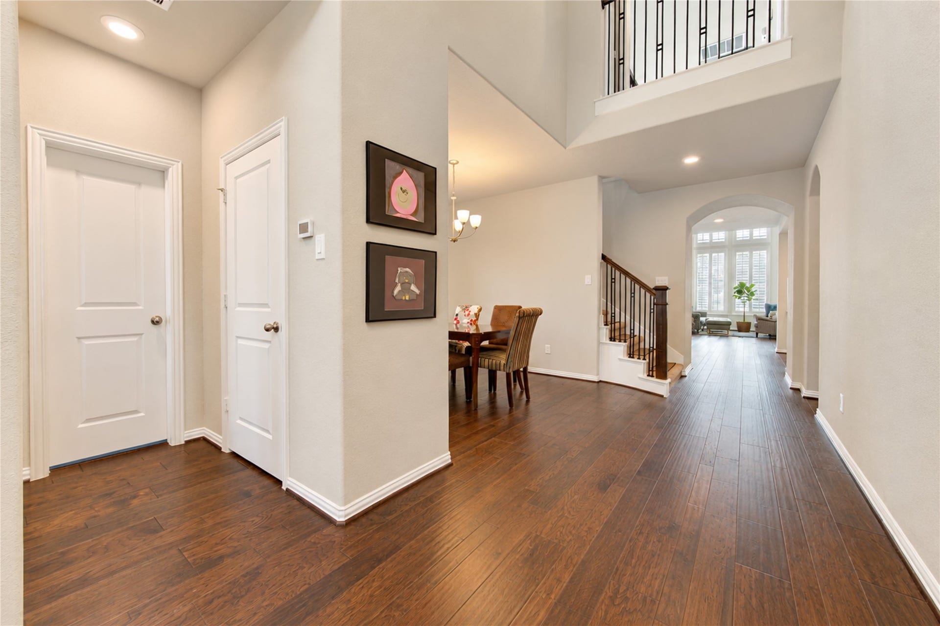 The homes impressive two-story entryway makes a grand first impression, featuring warm wood flooring and an elegant glass-and-wood front door that welcomes you inside.
