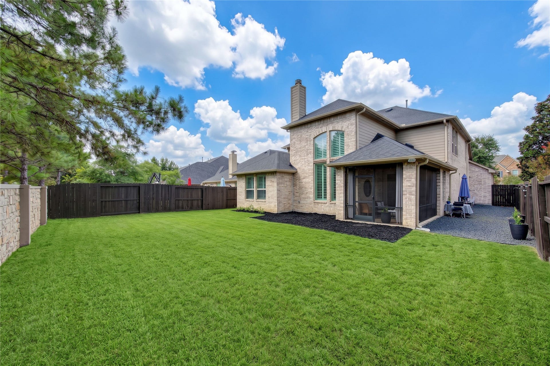 A screened-in, covered back patio offers the perfect place to enjoy your backyard day or night, rain or shine.
