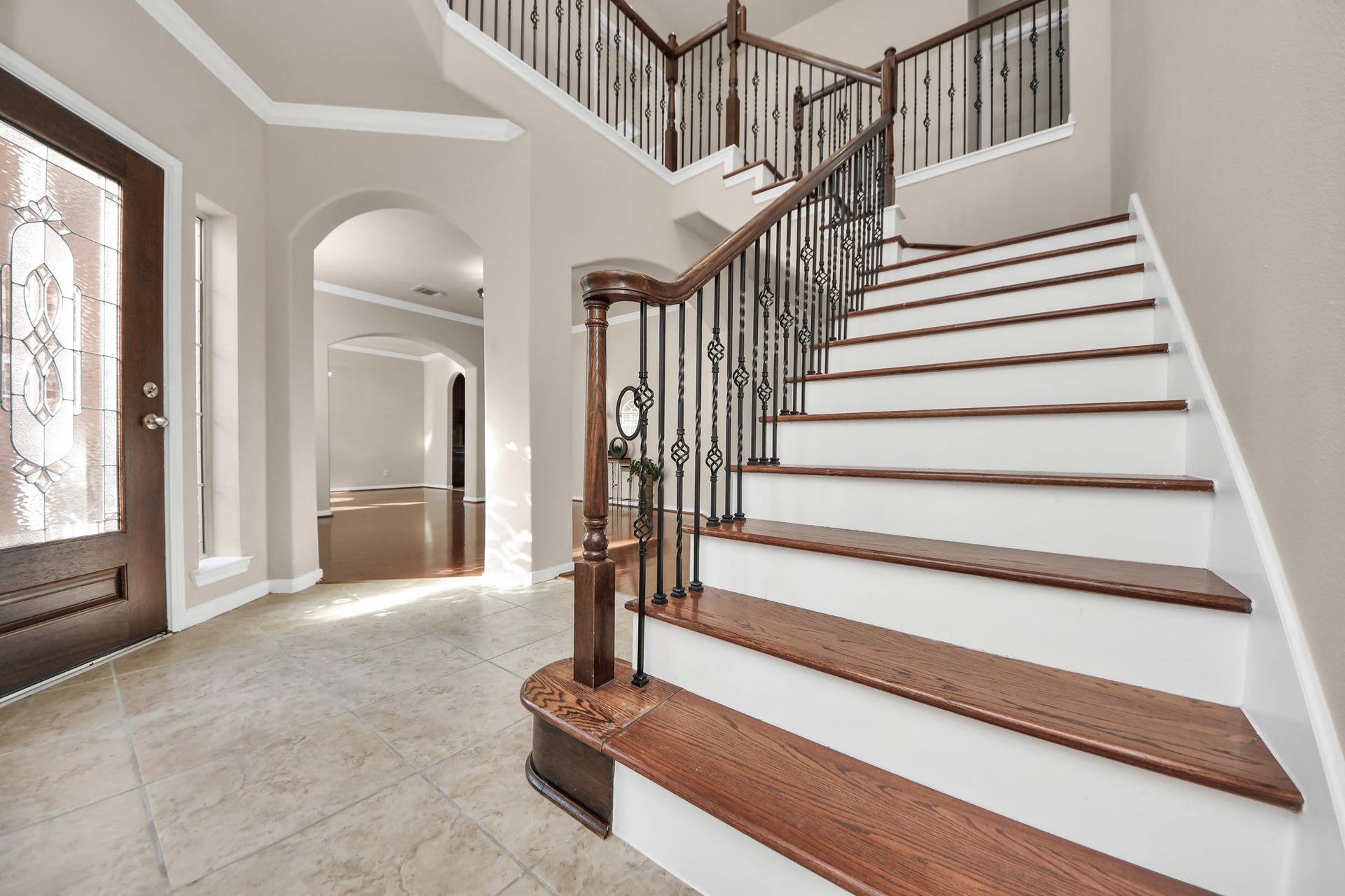17418 Memorial Mills Drive, Spring, TX 77379 Featuring pristine white risers and sophisticated wrought iron balusters, this striking staircase serves as a luxurious focal point immediately upon entering the home.