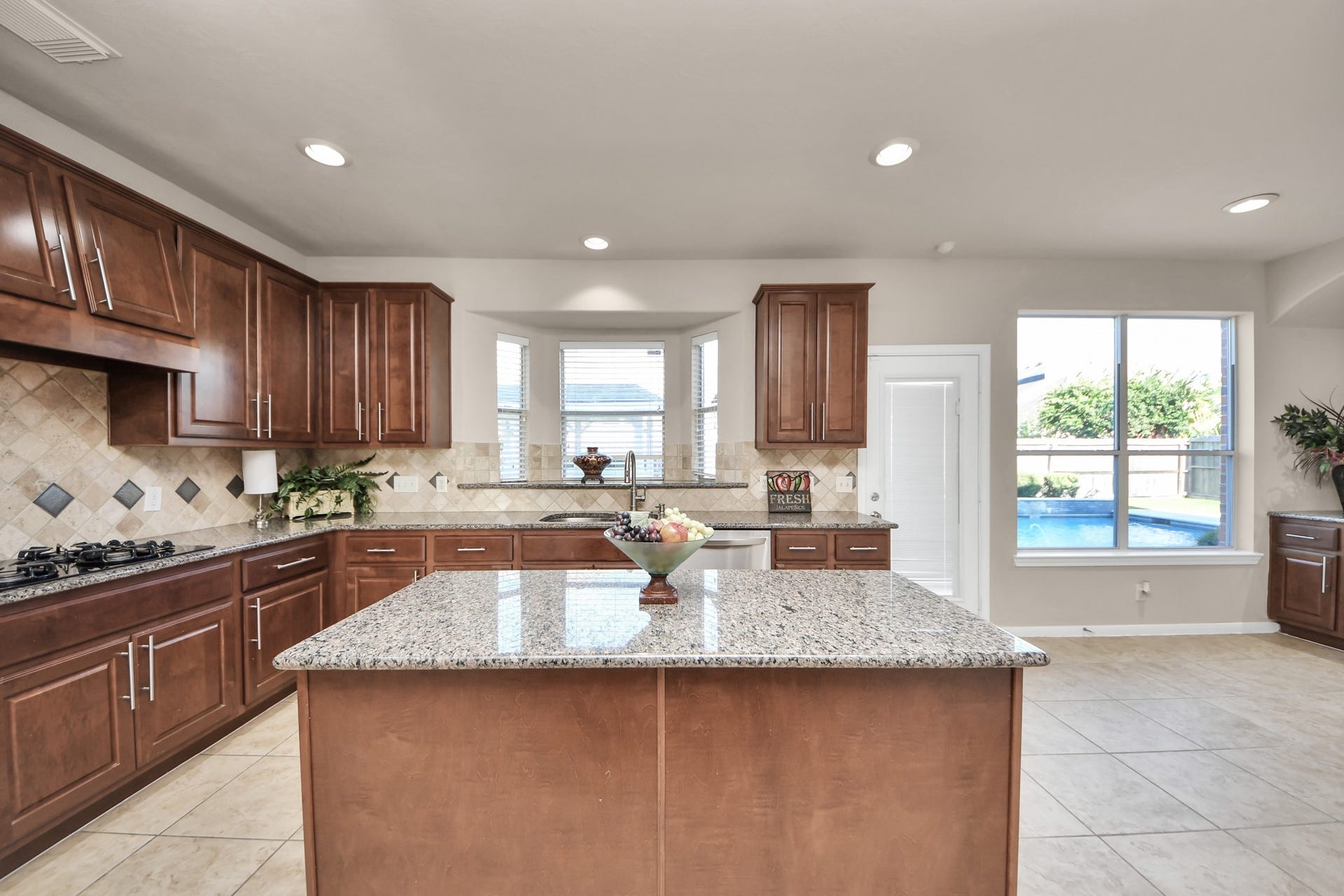 17418 Memorial Mills Drive, Spring, TX 77379 The kitchen features generous counter space, abundant storage, two walk-in pantries, and beautiful views of the pool.
