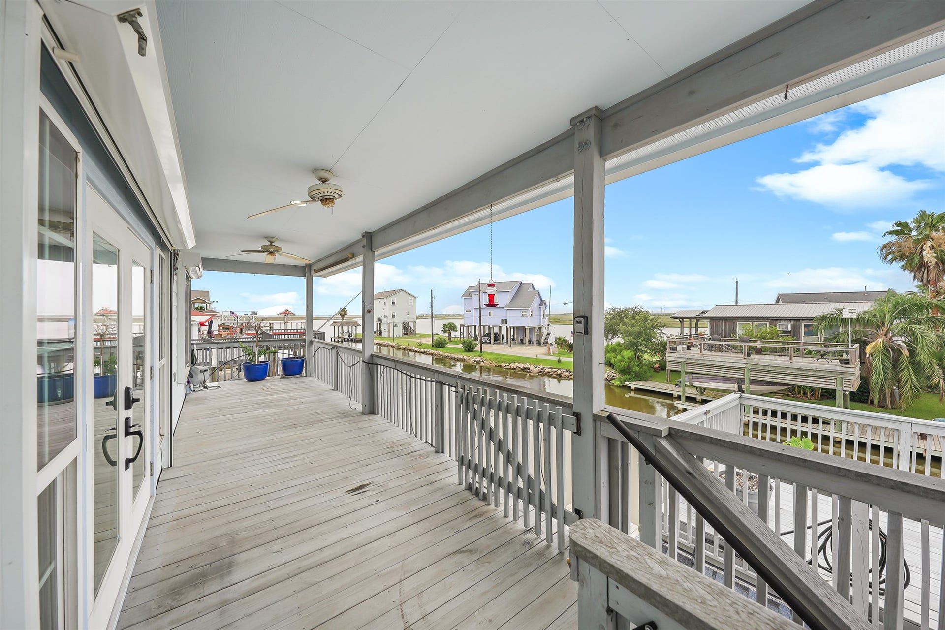 Deep covered back porch provides endless views of the wetlands beyond and incredible views of the sunset over the water