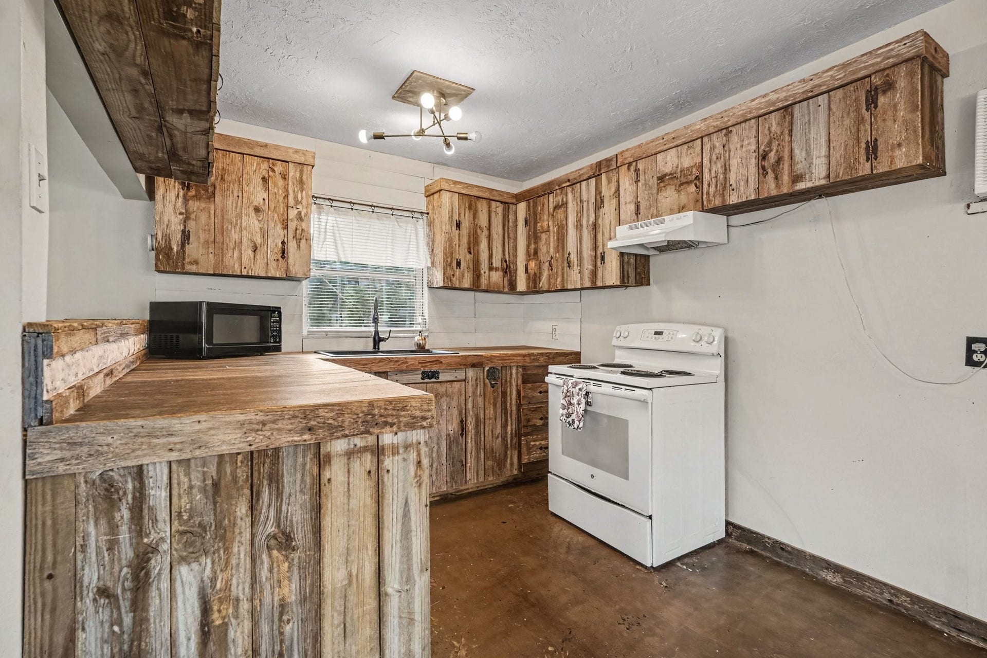 3315 Saint Anne Street, Liverpool, TX 77577 Rustic kitchen with charming wooden cabinetry, ample counter space, and a cozy atmosphere, perfect for culinary adventures.
