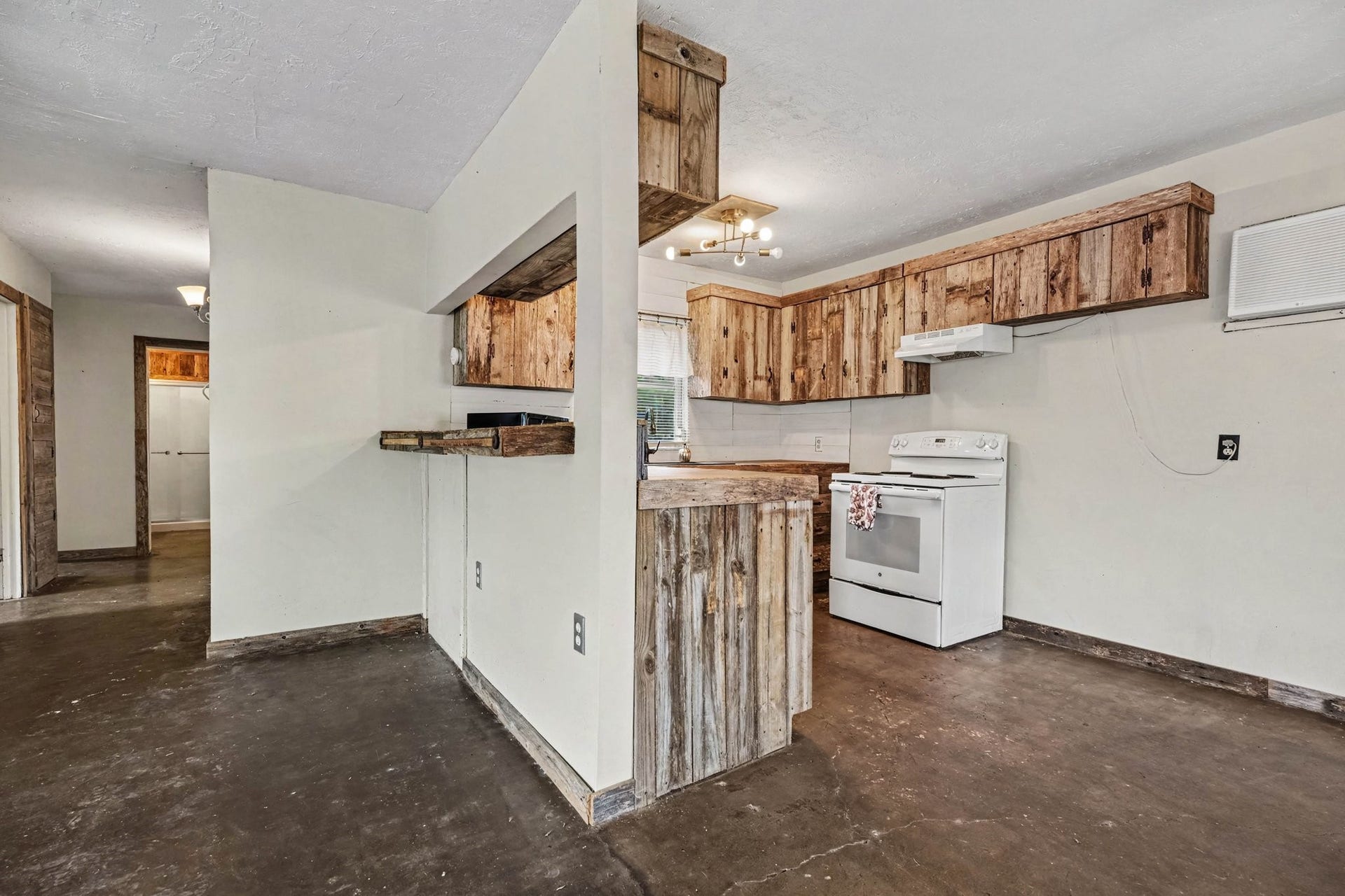 3315 Saint Anne Street, Liverpool, TX 77577 Charming rustic kitchen with wooden cabinetry and a cozy breakfast bar, featuring a white stove and ample counter space for culinary creativity.
