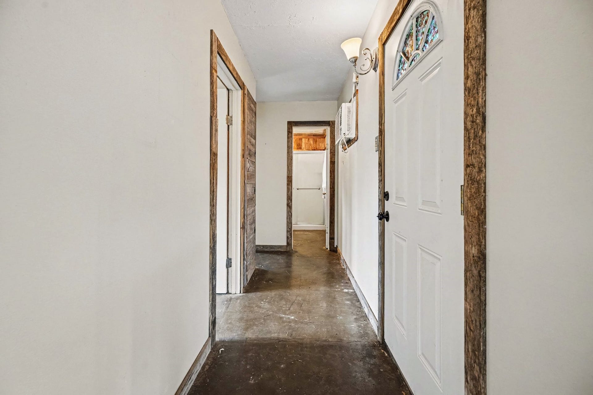 3315 Saint Anne Street, Liverpool, TX 77577 Inviting hallway with rustic wood trim, clean white walls, and a decorative front door, leading to multiple rooms for convenient access.