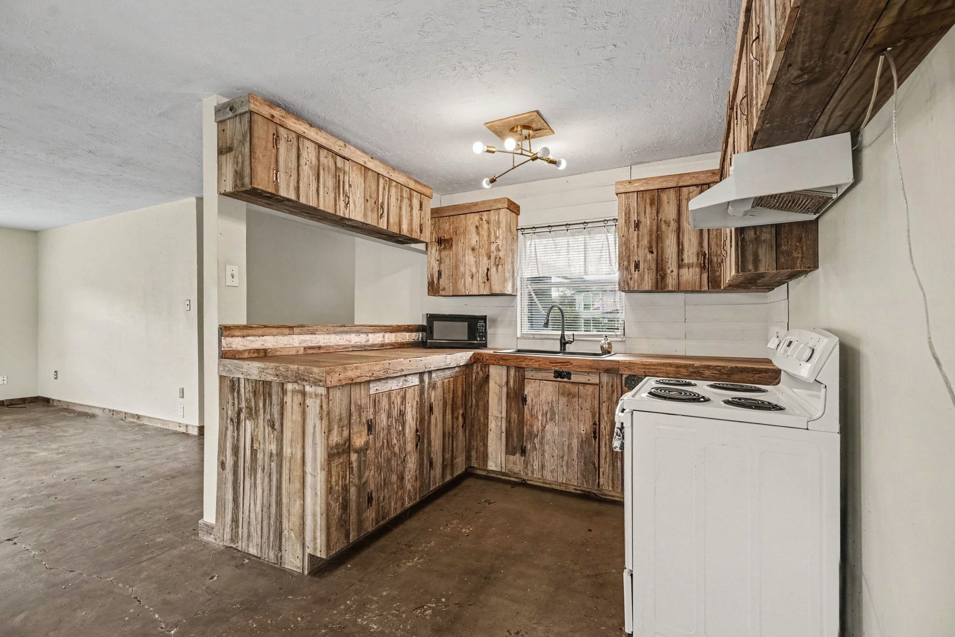 3315 Saint Anne Street, Liverpool, TX 77577 Charming rustic kitchen with wooden cabinetry, vintage-style appliances, and a cozy open layout, perfect for creative renovations.