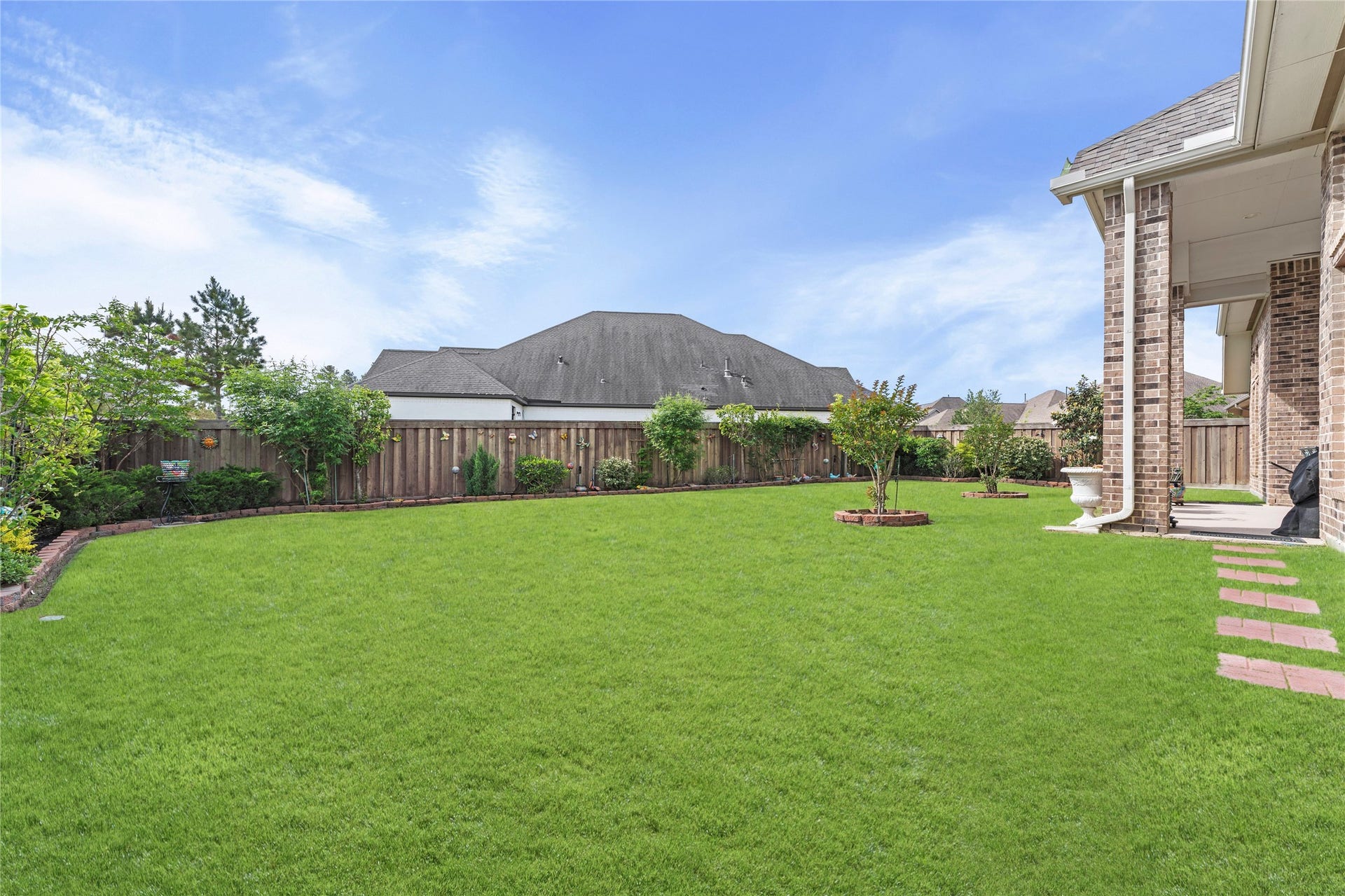 28155 Briarwood Pass, Spring, TX 77386 Lush backyard with greenery, like trees and plants on a large corner lot.