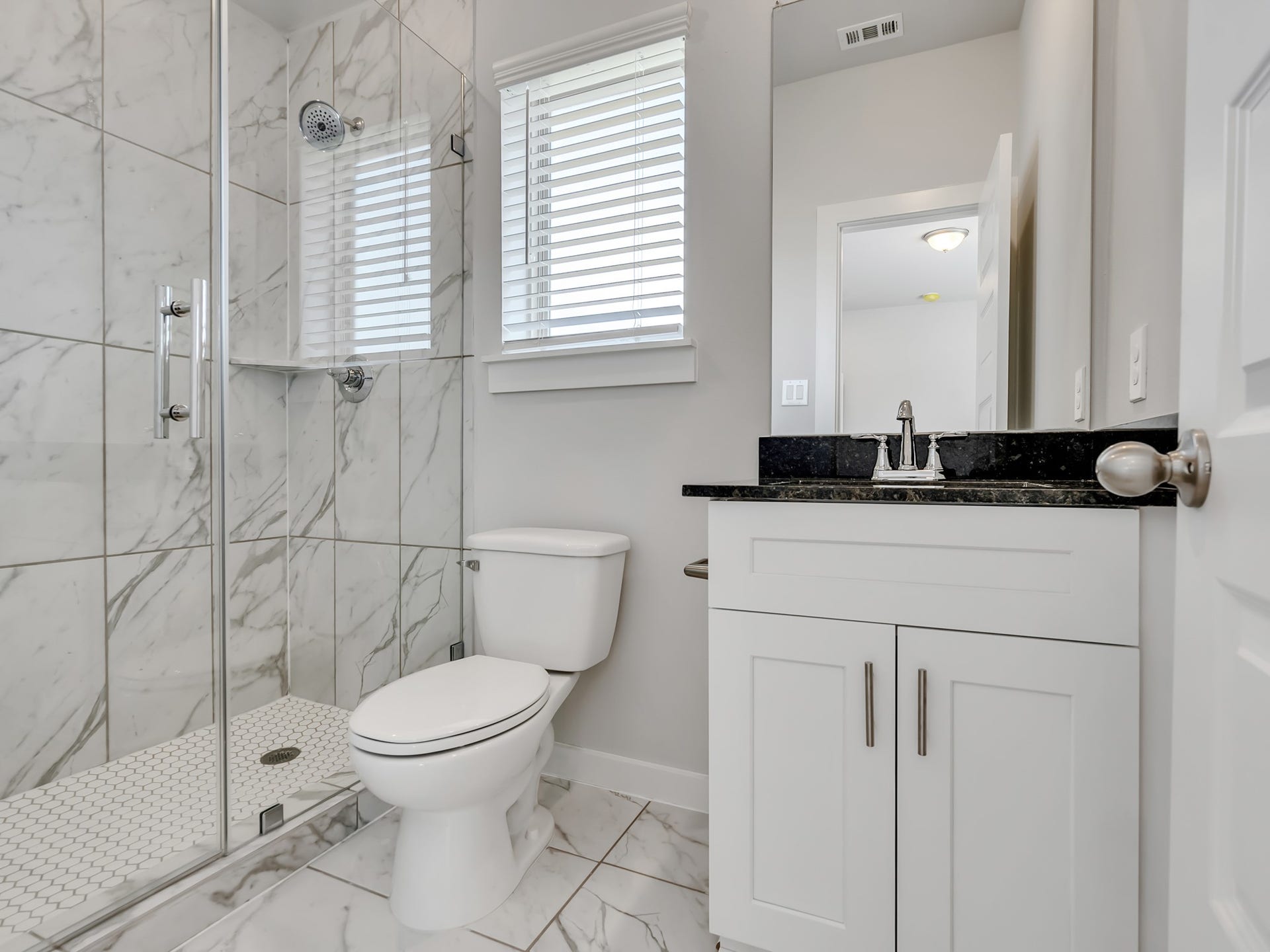 1206 Elsinore Drive, Rosharon, TX 77583 You'll love this modern bathroom featuring a frameless glass walk-in shower with a stylish hexagonal tile base.