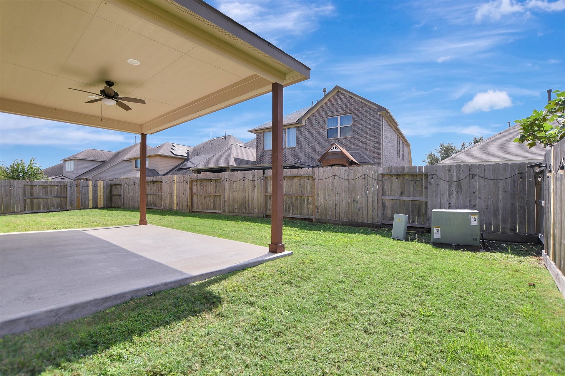 Large covered patio in a fully fenced backyard.