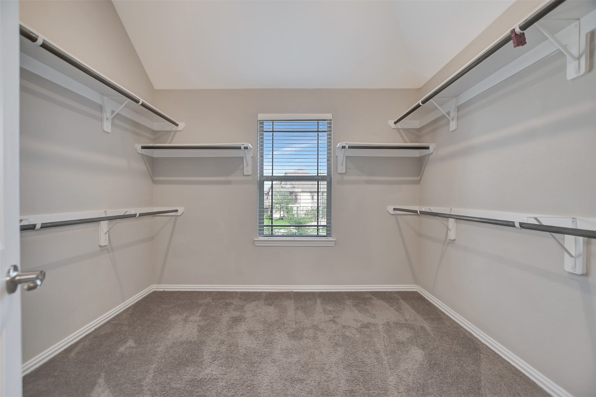 Large walk-in closet for him and hers clothing and accessories with natural light.