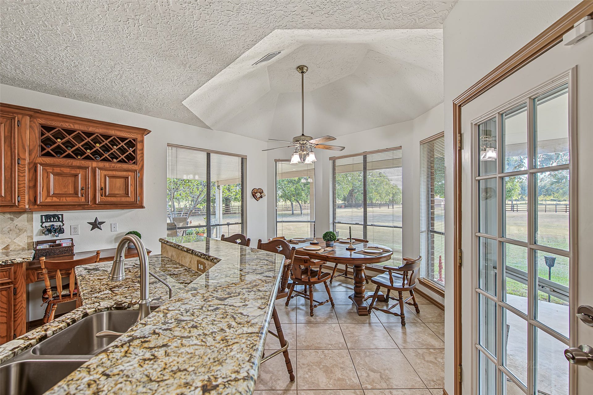 1345 Peach Ridge Road, Brookshire, TX 77423 At the heart of the home, this sun-drenched breakfast nook and open kitchen space boasts a dramatic vaulted octagonal ceiling complete with a central fan light fixture.