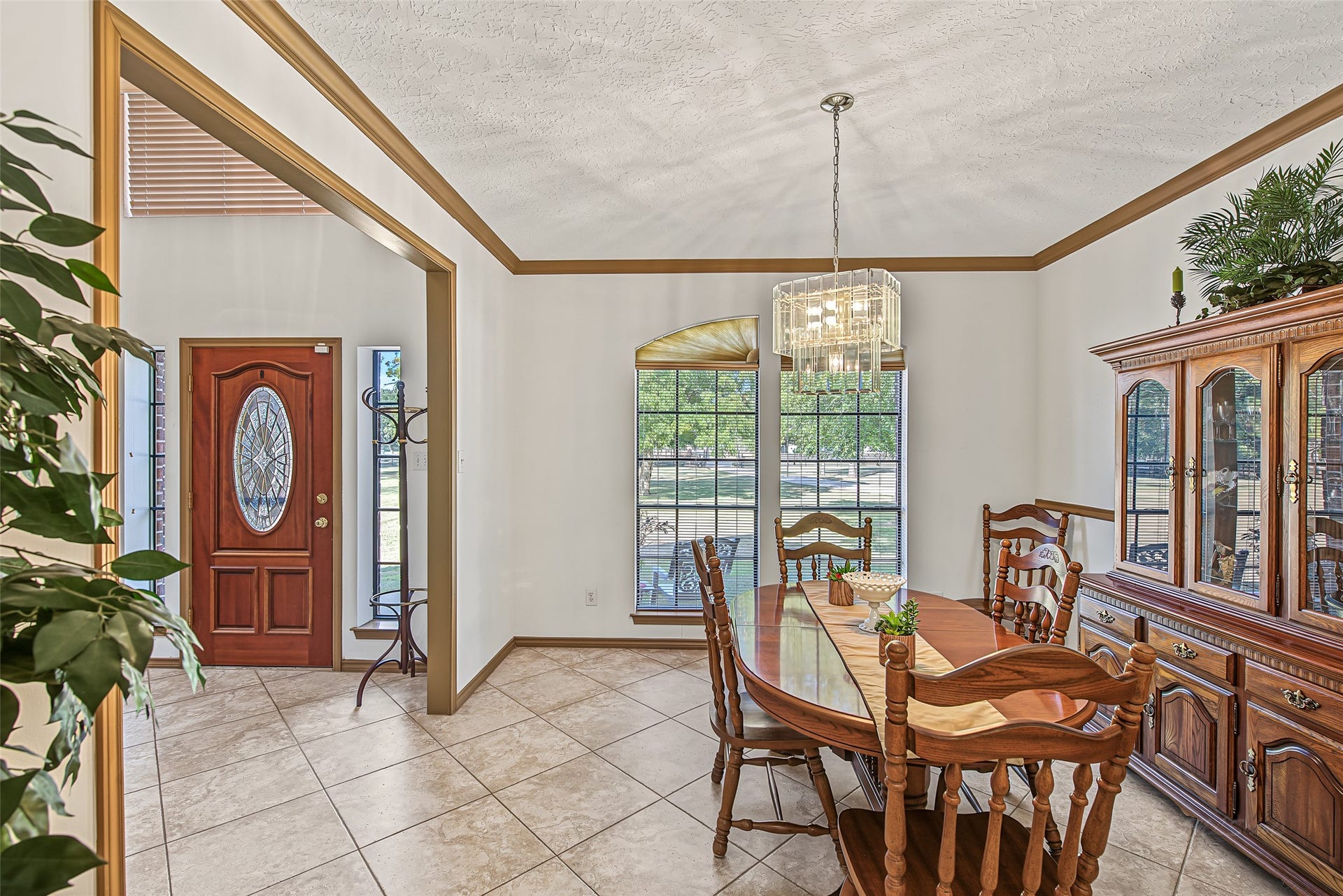 1345 Peach Ridge Road, Brookshire, TX 77423 Just right off the foyer, rich wood crown molding, a decorative chair rail, and diagonal-laid tile flooring. Illuminated by a classic crystal chandelier, this bright space offers a seamless layout that flows effortlessly into adjacent living areas while offering direct access to the nearby utility room.
