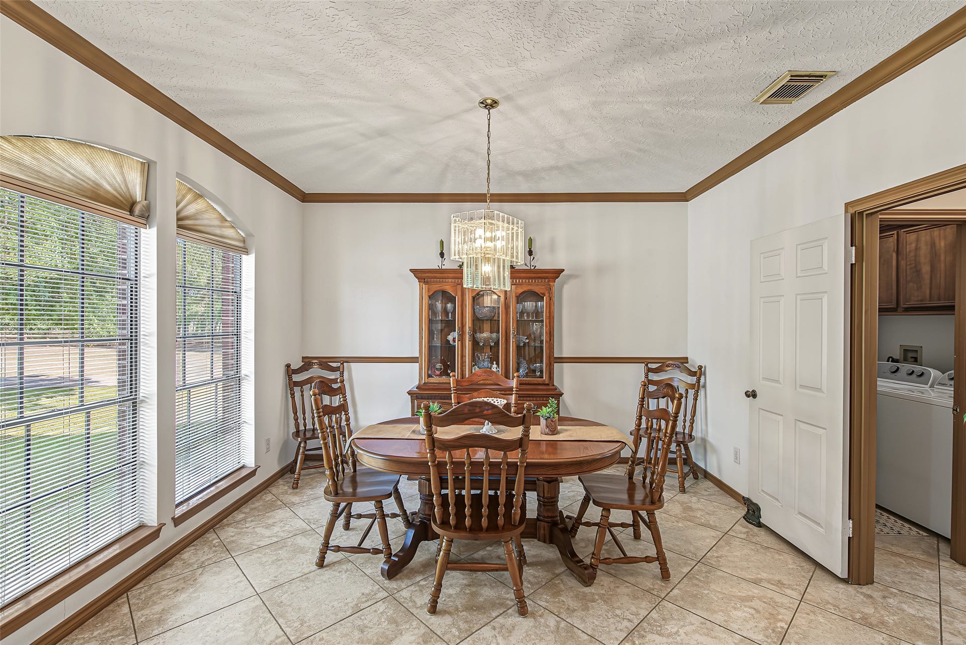 1345 Peach Ridge Road, Brookshire, TX 77423 Anchored by magnificent floor-to-ceiling arched windows that flood the room with natural light, this formal dining room provides an elegant setting for everyday meals and special gatherings.