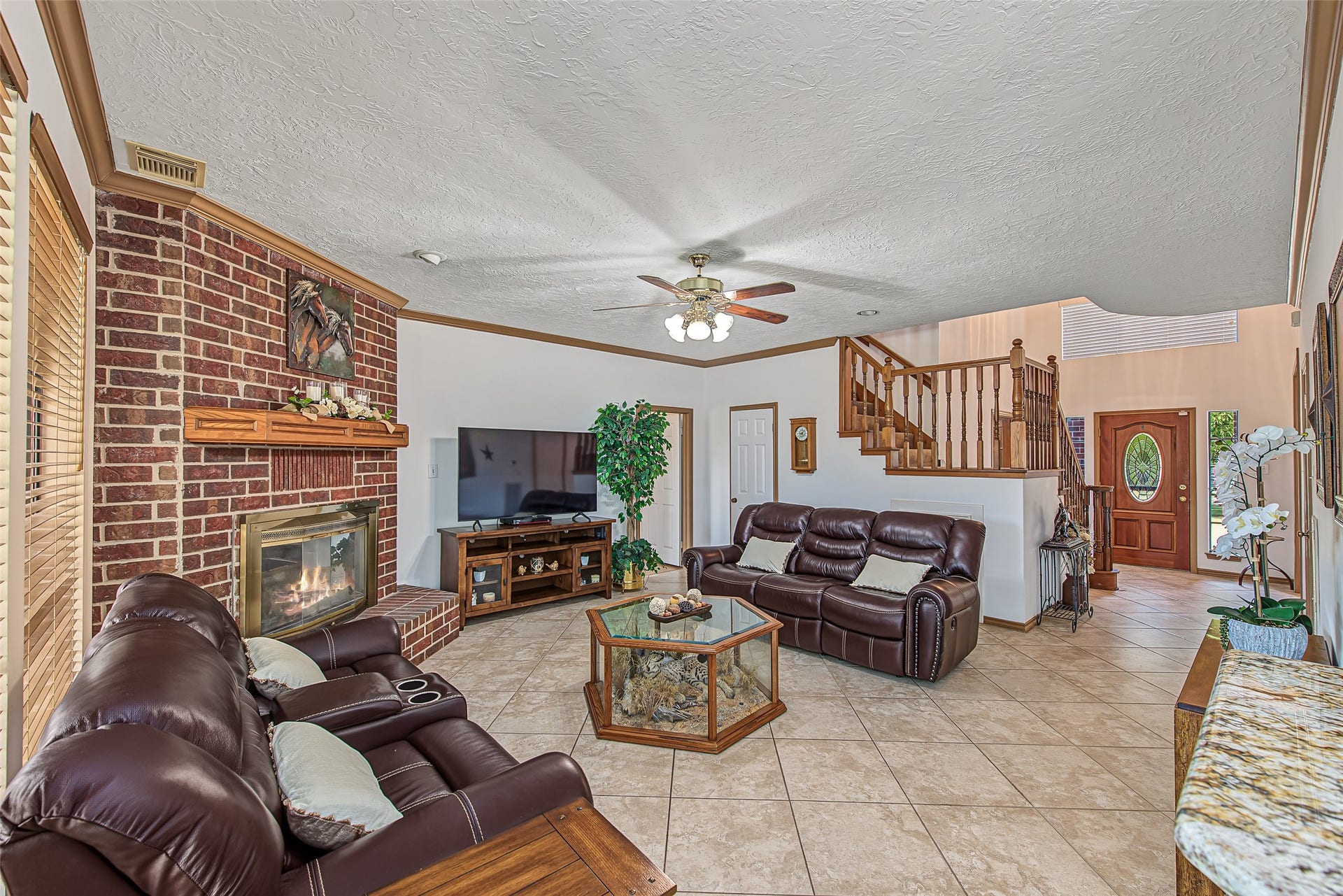 1345 Peach Ridge Road, Brookshire, TX 77423 Framed by rich crown molding and warm tile flooring, the open-concept layout transitions into the two-story entry foyer and staircase, creating an expansive flow for entertaining.