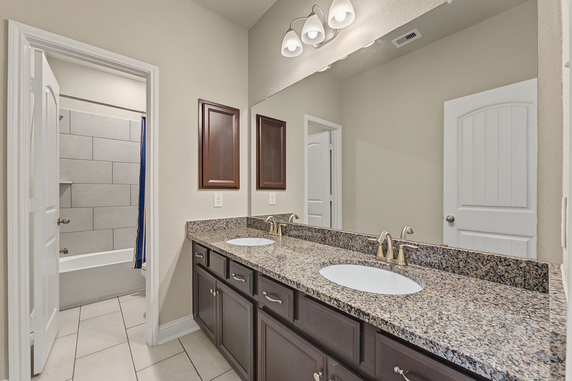 16 Centennial Ridge Place, The Woodlands, TX 77354 The secondary bathroom features double sinks, an expansive amount of counter space & storage. Notice the separate tub/shower and potty!