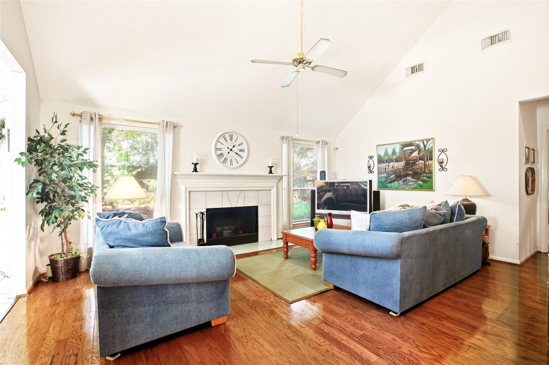 Family room centered on a tile-surround fireplace flanked by windows for natural light.