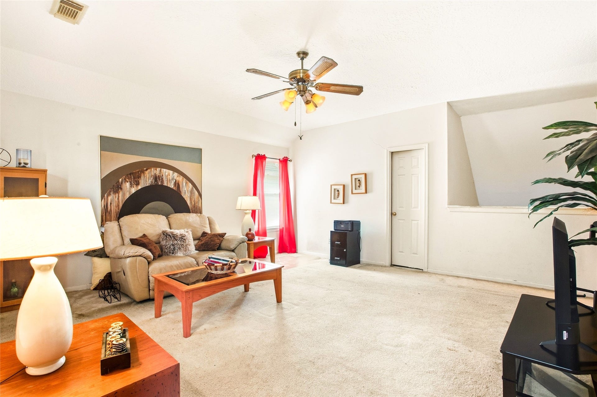 Game room with ceiling fan and carpet, offering flexible space for media or recreation.