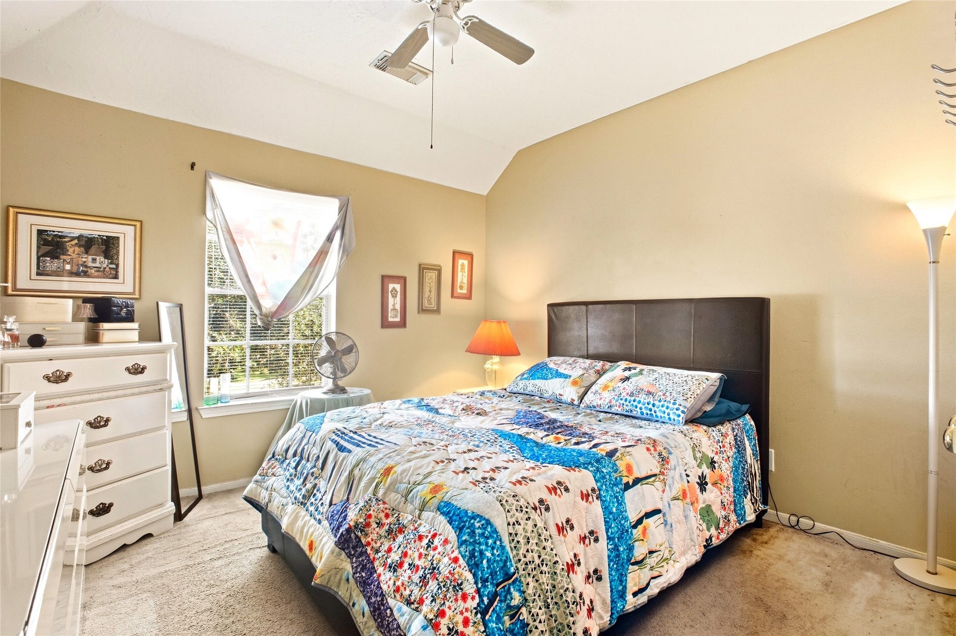 Secondary bedroom with carpet, ceiling fan, and window.