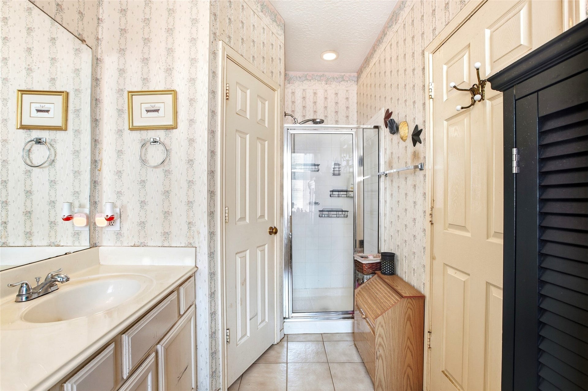 Primary bath with a separate shower, vanity, and tile flooring.