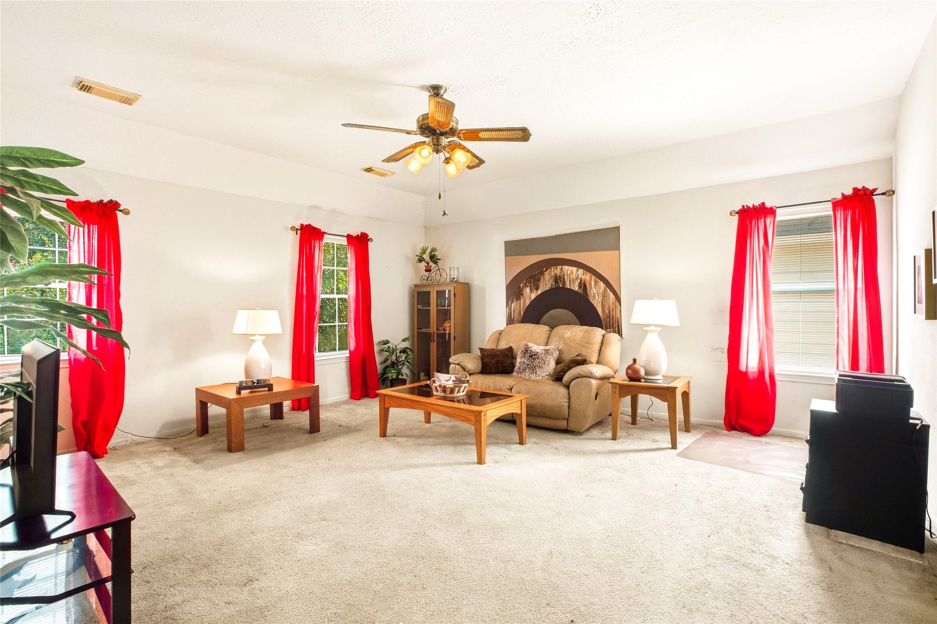 Game room filled with natural light from three windows, with room for multiple seating areas.