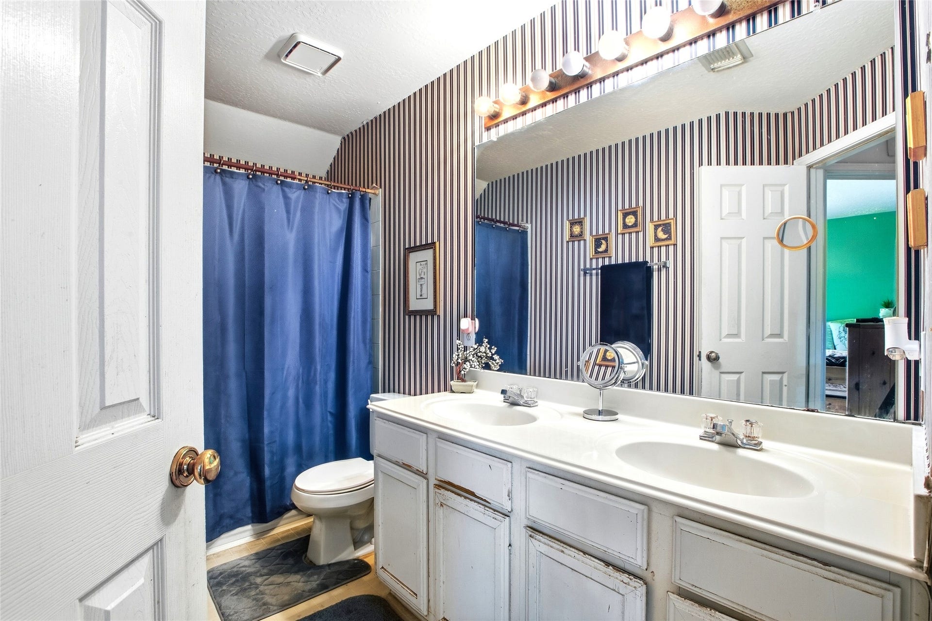 Secondary bath with a double-sink vanity and tub/shower combination.